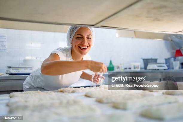 joyful baker preparing dough for baking in industry. - bakery stock pictures, royalty-free photos & images