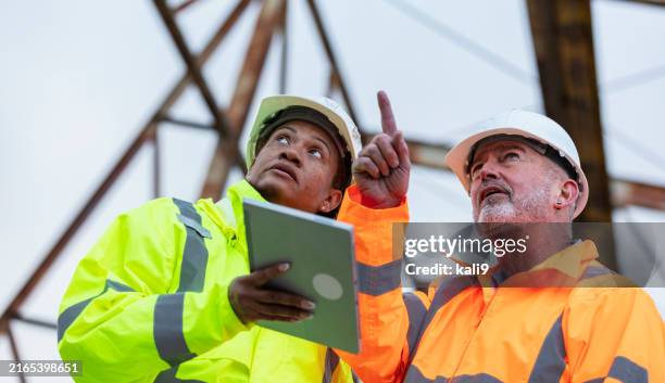 engineers at construction site with digital tablet - steel worker stock pictures, royalty-free photos & images