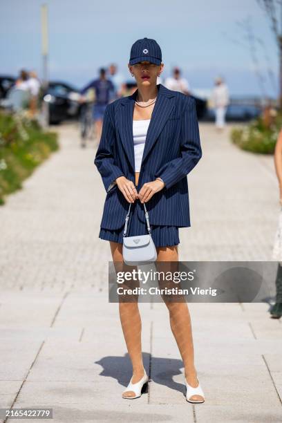 Katya Tolstova is seen wearing striped navy cap, blazer, skirt, grey Prada bag, shirt, beige tights with print outside OpéraSport during the...