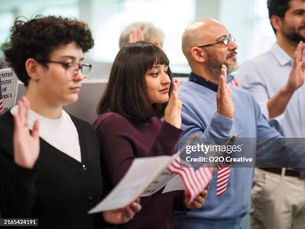 gruppe von personen, die den treueid auf die einbürgerung in die usa ablegen - amerikanischer treueschwur stock-fotos und bilder