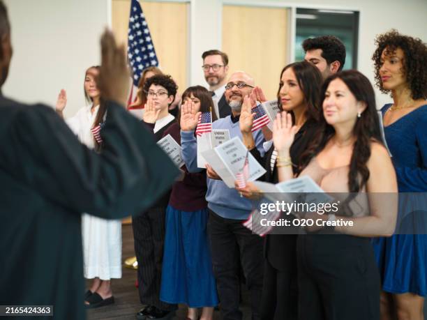 gruppe von personen, die den treueid auf die einbürgerung in die usa ablegen - amerikanischer treueschwur stock-fotos und bilder