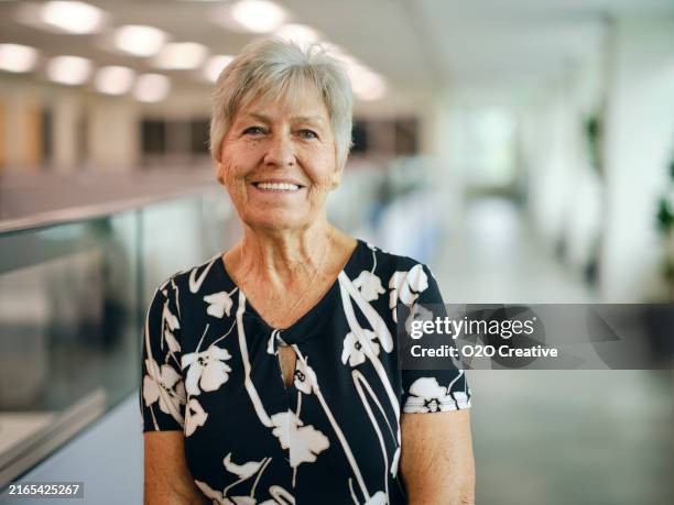portrait of a woman in an office - werkende bejaarden stockfoto's en -beelden