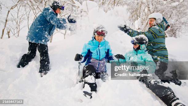 two parents playing in the snow with their children - family skiing stock pictures, royalty-free photos & images