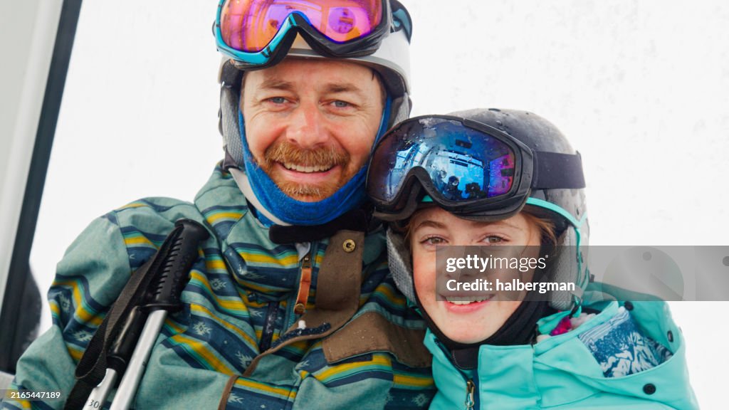 Portrait of Father and Daughter Smiling Inside Ski Gondola