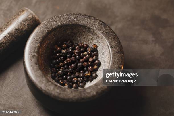 juniper berries in a mortar - granite mortar and pestle stock pictures, royalty-free photos & images