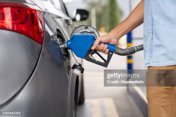 homme de faire le plein de sa voiture dans une station-service - station-service photos et images de collection