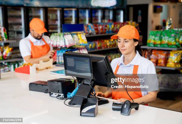 cashier working at a convenience store at a gas station - gemakswinkel stockfoto's en -beelden