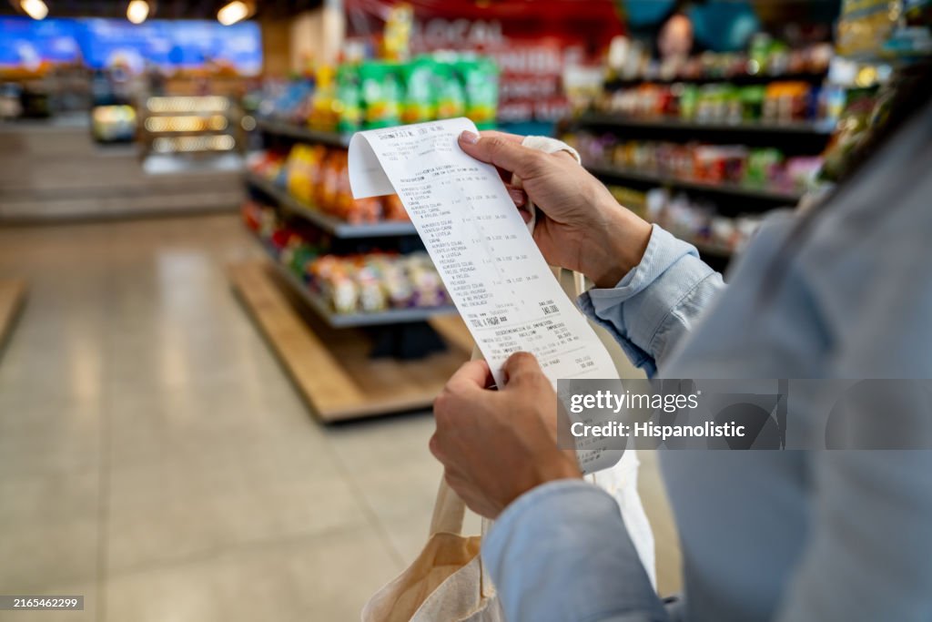 Mujer comprando en una tienda de conveniencia y revisando su recibo