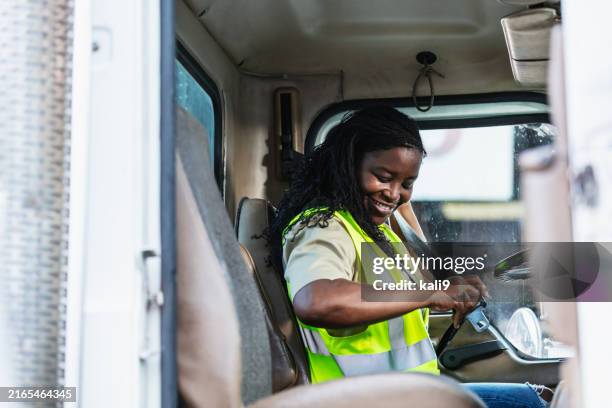 black woman truck driver buckling seat belt - vrachtwagenchauffeur stockfoto's en -beelden