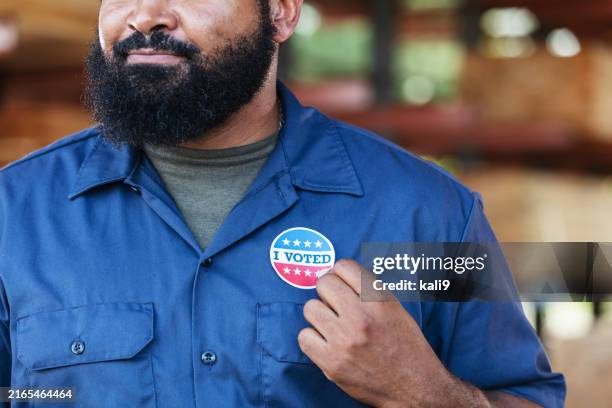 african-american man in lumberyard, with i voted sticker - votação imagens e fotografias de stock