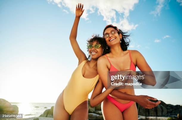 two young women in swimwear laughing during a beach day in summer - badkläder bildbanksfoton och bilder