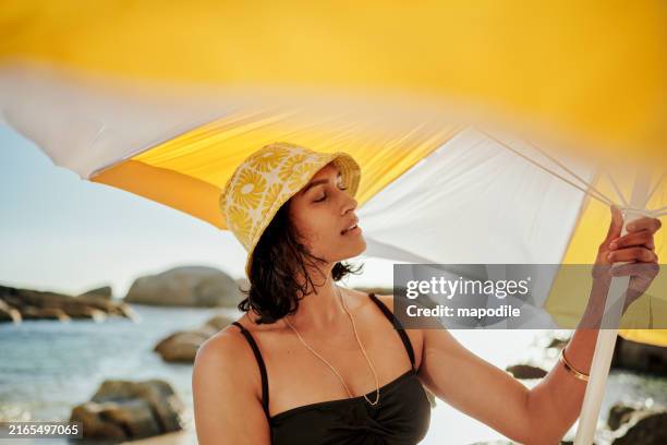 jeune femme posant un parapluie sur une plage en été - parasol photos et images de collection
