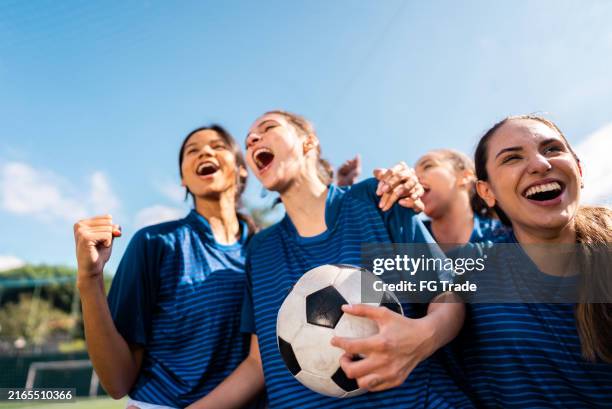 soccer players celebrating on soccer field - calcio femminile foto e immagini stock