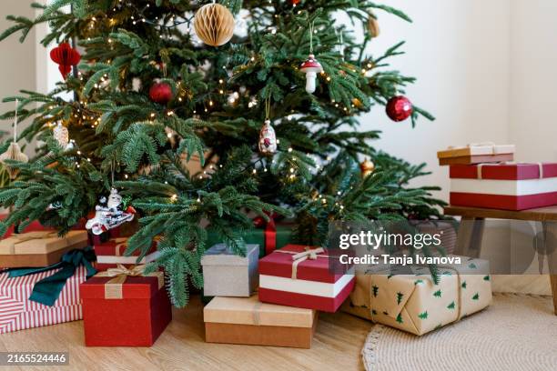 christmas gifts on background of a christmas tree. new year's present and christmas present. - regalos navidad fotografías e imágenes de stock