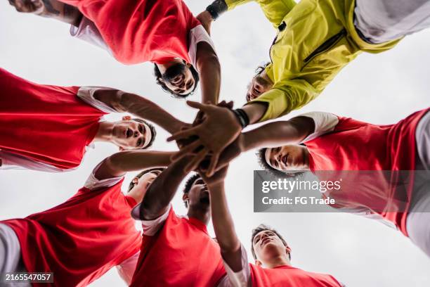soccer team stacking hands in the soccer field - soccer competition stock pictures, royalty-free photos & images