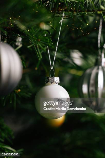 white bauble on christmas tree - decorating-the-christmas-tree stock pictures, royalty-free photos & images