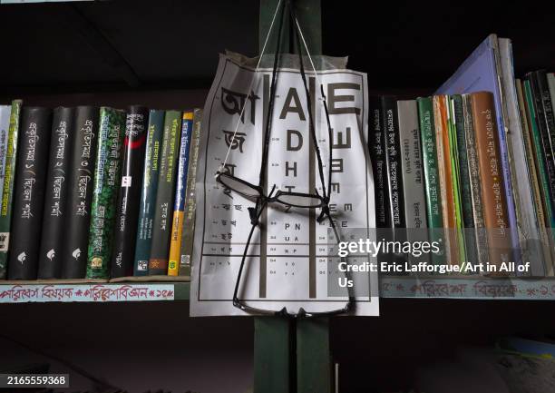 Reading glasses on display and eyesight test chart at a library, Rajshahi Division, Manda, Bangladesh on April 4, 2024 in Manda, Bangladesh.