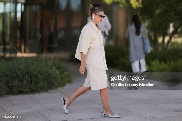Sophia Geiss is seen wearing narrow black sunglasses from Saint Laurent, white earrings in the shape of a bow, a two-piece consisting of an oversized...