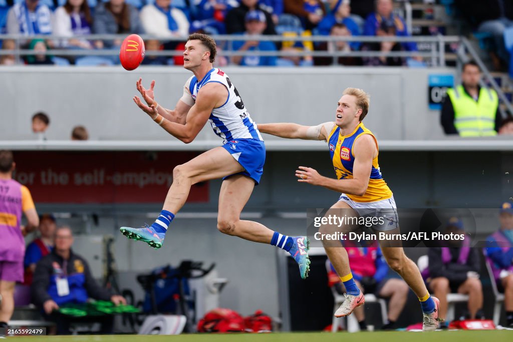 Comben Charlie Comben of the Kangaroos marks the ball ahead of Oscar Allen ...