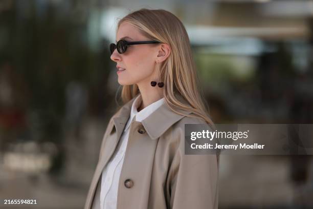 Fashion week guest is seen wearing a long white blouse with a white collar and short white fabric trousers, a long beige coat with a collar, white...