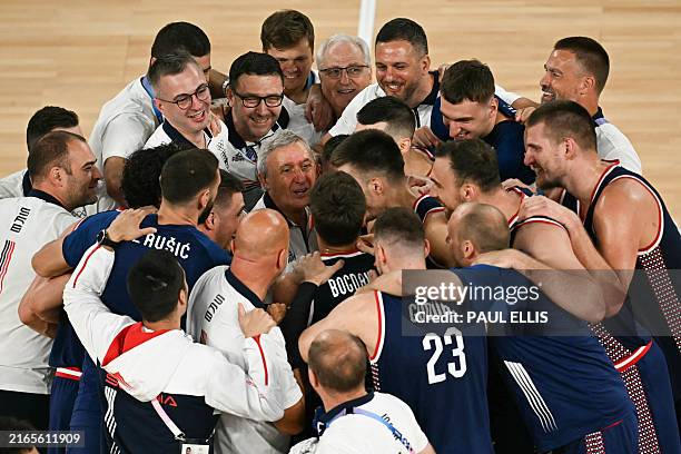 Serbia's team players surround Serbia's coach Svetislav Pesic as they celebrate winning the men's Bronze Medal basketball match between Germany and...
