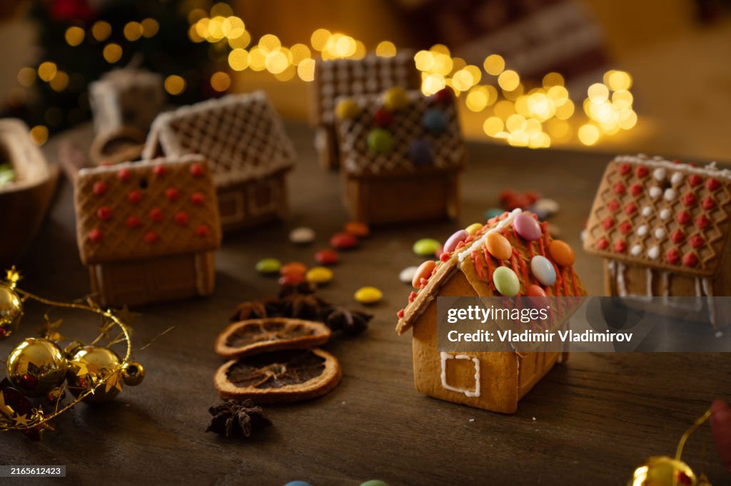 Many gingerbread houses standing on the table in a cozy atmosphere