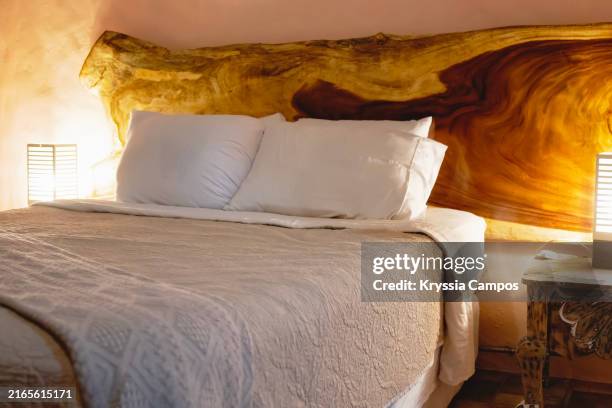 white pillows on a cozy bed with beige bedspread and wooden headboard - headboard stock pictures, royalty-free photos & images