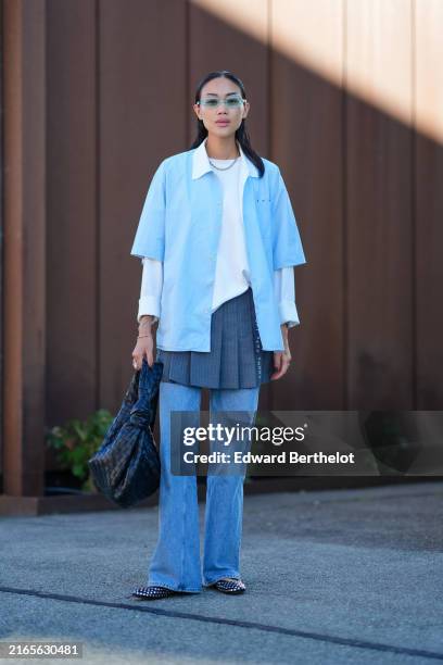 Guest wears clear green sunglasses, silver chain necklace, white long sleeve shirt, light blue short sleeve unbuttoned shirt, navy blue pleated mini...