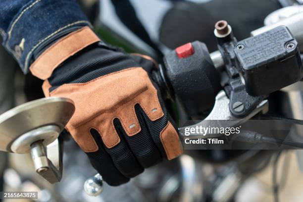 gloved hand operating motorcycle handlebar and throttle - motorcycle throttle stock pictures, royalty-free photos & images
