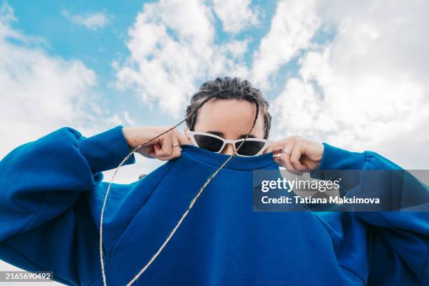 funny young woman in fashionable sunglasses and braids instead beard. - industria textil fotografías e imágenes de stock