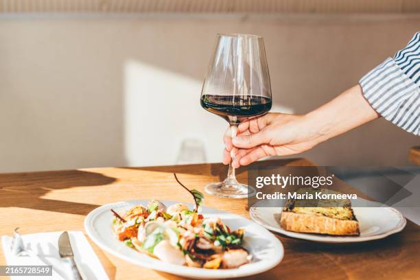 woman tasting wine in a restaurant. - rode wijn stockfoto's en -beelden