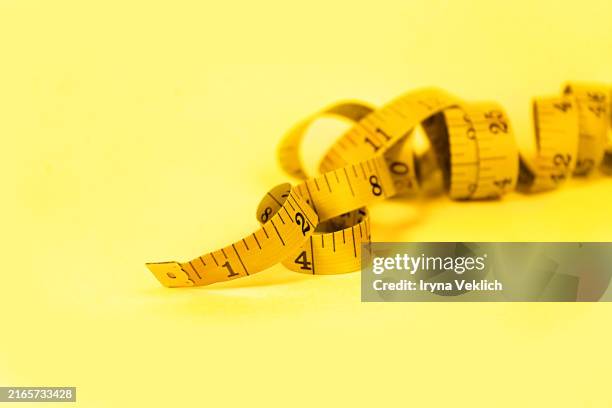 yellow measuring tape on yellow background. - unidade de medida - fotografias e filmes do acervo