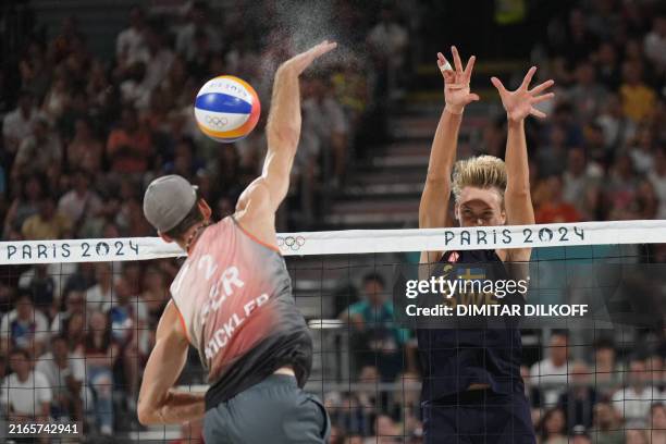 Germany's Clemens Wickler spikes the ball as Sweden's Jonatan Hellvig blocks in the men's gold medal beach volleyball match between Sweden and...