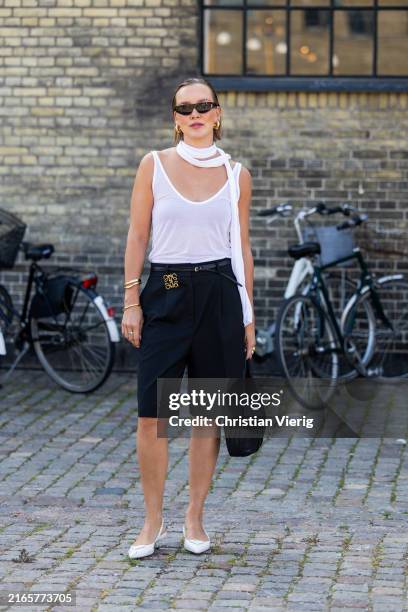 Tina Haase wears white shirt, Loewe accessoires, black shorts, bag outside Herskind during day three of the Copenhagen Fashion Week SS25 on August...