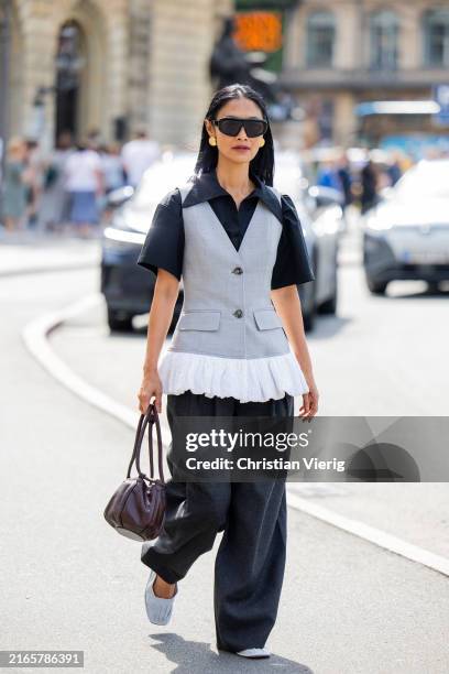 Pornwika Spiecker wears grey vest, wide leg pants, brown bag, button shirt outside Mark Kenly Domino Tan during day three of the Copenhagen Fashion...