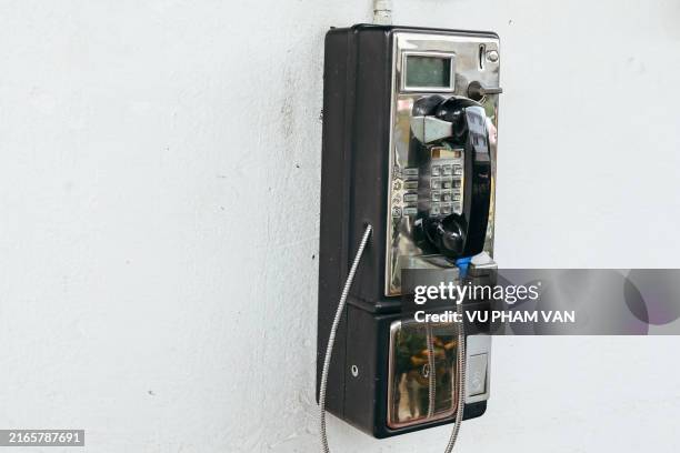 close up view of a coin phone hanging on wall - pay phone stock pictures, royalty-free photos & images