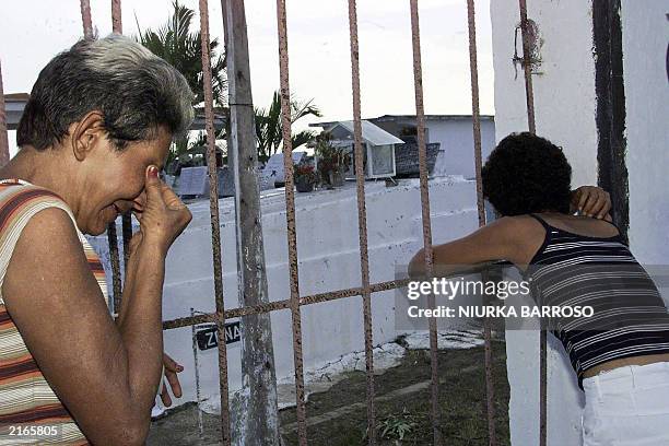 Maria Acosta Valdes and Caridad Acosta Placeres, the mothers of Luis Alberto Suarez and Yosvani Martinez respectively, cry in front of the locked...