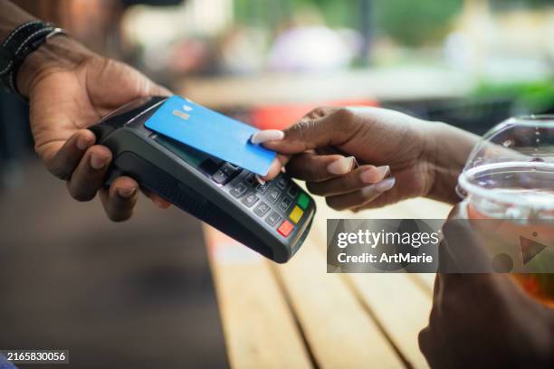young woman paying with credit card in a cafe - credit card art stock pictures, royalty-free photos & images