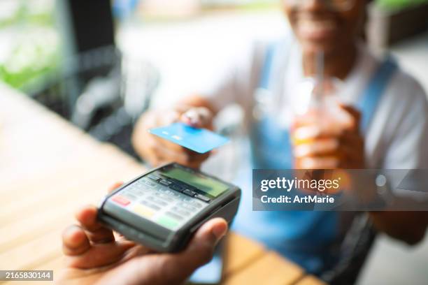 young woman paying with credit card in a cafe - credit card art stock pictures, royalty-free photos & images