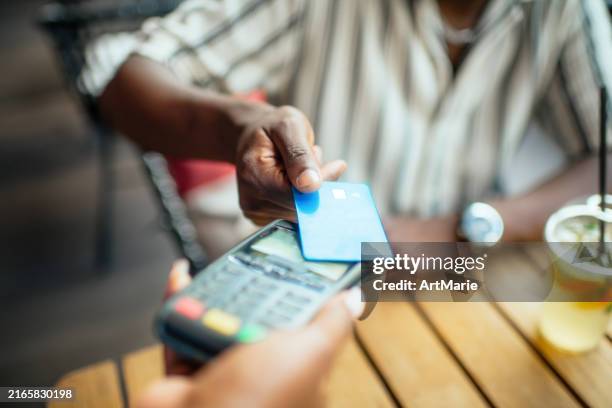 young man paying with credit card in a cafe - credit card art stock pictures, royalty-free photos & images