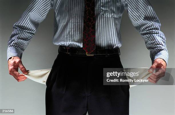 man holding out empty pants pockets - faillissement stockfoto's en -beelden