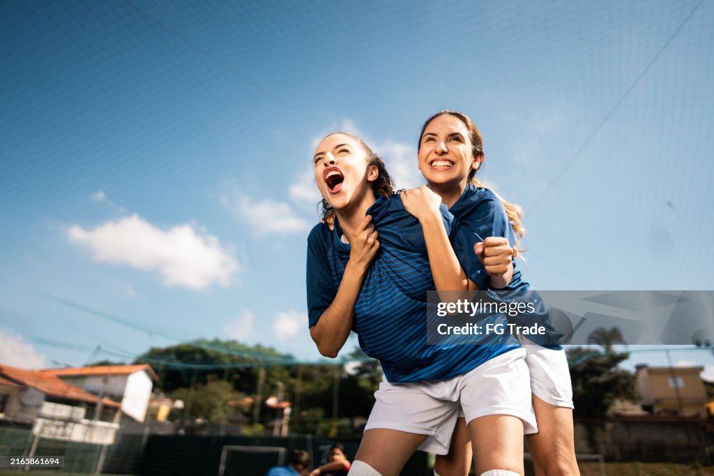 Soccer players celebrating on soccer field