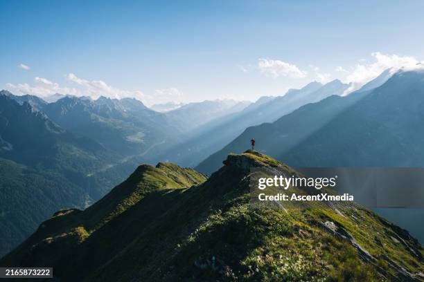trail runner bounds along mountain trail - mid distance stock pictures, royalty-free photos & images