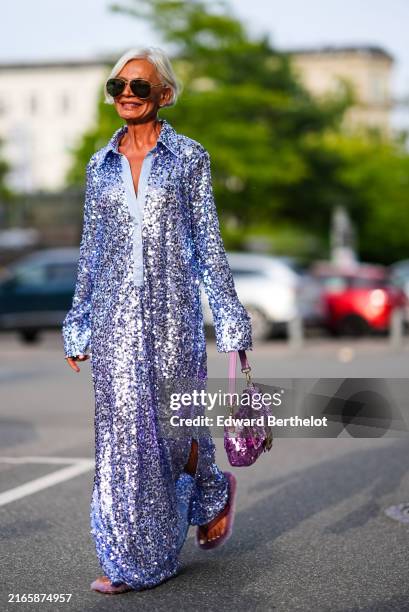 Grece Ghanem wears brown sunglasses, gold earrings, light purple sequin long sleeve maxi dress, dark pink Fendi sequin bag, outside Baum und...