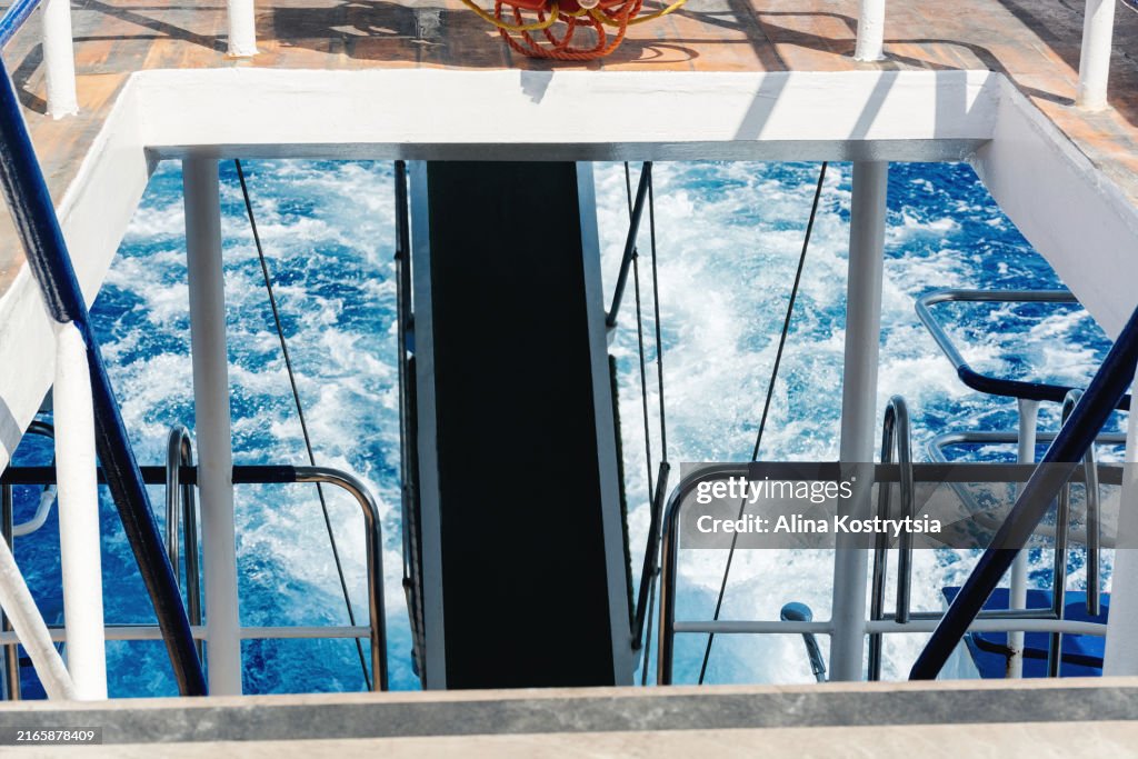 Back of yacht or boat with open view of rough water rising behind vessel