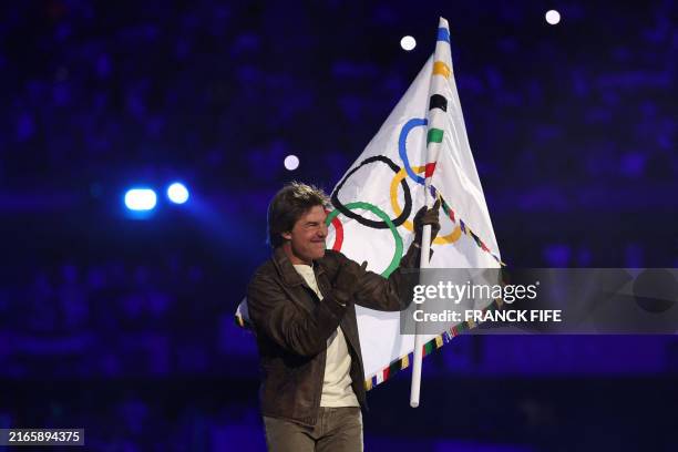 Actor Tom Cruise waves the Olympic flag during the closing ceremony of the Paris 2024 Olympic Games at the Stade de France, in Saint-Denis, in the...
