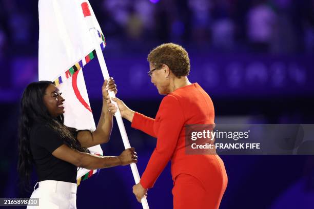 Los Angeles' Mayor Karen Bass gives the Olympic flag to US' gymnasts Simone Biles during the closing ceremony of the Paris 2024 Olympic Games at the...