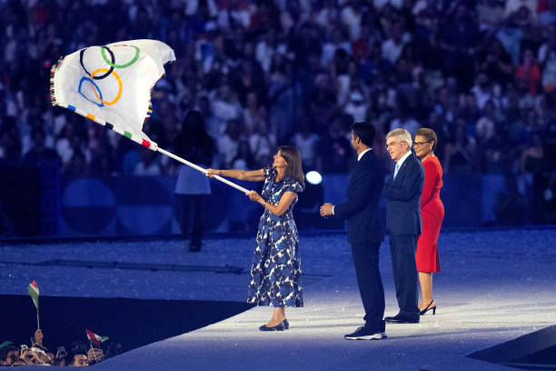August 2024, France, Paris: Olympia, Paris 2024, Stade de France, Anne Hidalgo , Mayor of Paris, waves the Olympic flag in the presence of Tony...