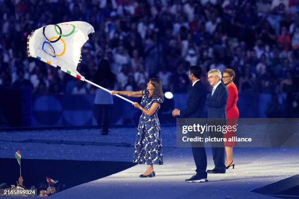 August 2024, France, Paris: Olympia, Paris 2024, Stade de France, Anne Hidalgo , Mayor of Paris, waves the Olympic flag in the presence of Tony...