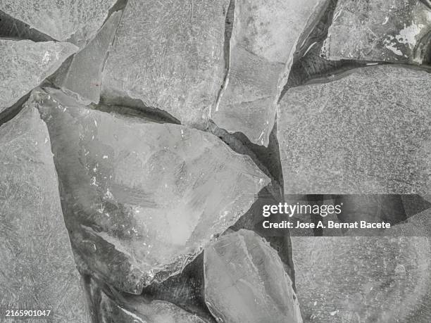 full frame, ice chunks floating on a frozen water surface. - broken ice stock pictures, royalty-free photos & images